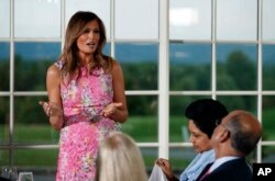 FILE - First lady Melania Trump speaks during a dinner meeting with President Donald Trump and business leader in Bedminster, N.J.