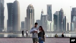 A couple take a weekend walk with their new born baby along the waterfront, in Doha, Qatar, May 4, 2018. 