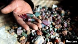FILE - A Congolese mineral trader displays semi-precious tourmaline gem stones in a mud hut at Numbi in eastern Congo.