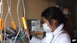 Nurse Tomimo Goto prepares medicine in the darkened ward of the Sen-en Hospital in Tagajo, Japan