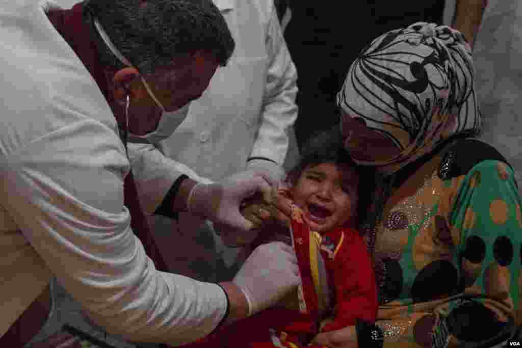Para dokter memeriksa kesehatan seorang anak Suriah di klinik dalam kamp pengungsi. Di antara masalah yang paling umum adalah penyakit pernafasan seperti bronkhitis. (VOA/John Owens)