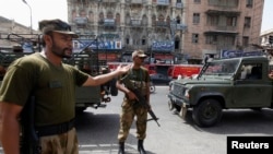 Des paramilitaires montent la garde le long d'une route à l'extérieur du tribunal de district de la ville de Karachi le 10 mai 2013.