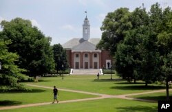 FILE - People walk on Johns Hopkins University's Homewood campus in Baltimore, Maryland.