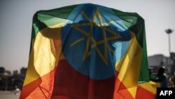 FILE - A man covers himself with an Ethiopian flag during a rally in Addis Ababa, Ethiopia, Nov. 7, 2021, in support of the national defense forces.