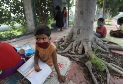 Anak-anak belajar di kelas yang digelar di pinggir jalan oleh pasangan suami-istri, Virendra dan Veena Gupta, di New Delhi, India, 3 September 2020 .(Foto: AP)