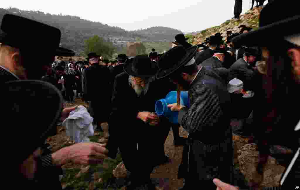 An ultra-Orthodox Jew pours water collected from a spring during the traditional Jewish rite of "Mayim Shelanu" in the Jerusalem mountains. The water is used to prepare matzoh. (Reuters)