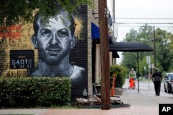 A mural of Lee Harvey Oswald painted on a wall outside a barbershop in Dallas, Aug. 26, 2016.