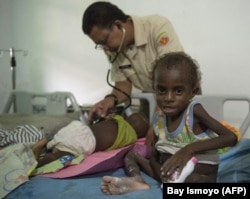 Anggota Satgas TNI memeriksa anak di rumah sakit setempat di Agats, Ibu Kota Kabupaten Asmat pada 26 Januari 2018.(Foto: AFP/Bay Ismoyo)