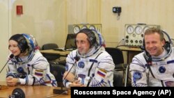 L'actrice Yulia Peresild, à g., le réalisateur Klim Shipenko, à dr., et le cosmonaute Anton Shkaplerov parlent avec leurs proches avant leur départ au cosmodrome de Baikonur, au Kazakhstan, mardi 5 octobre 2021. 