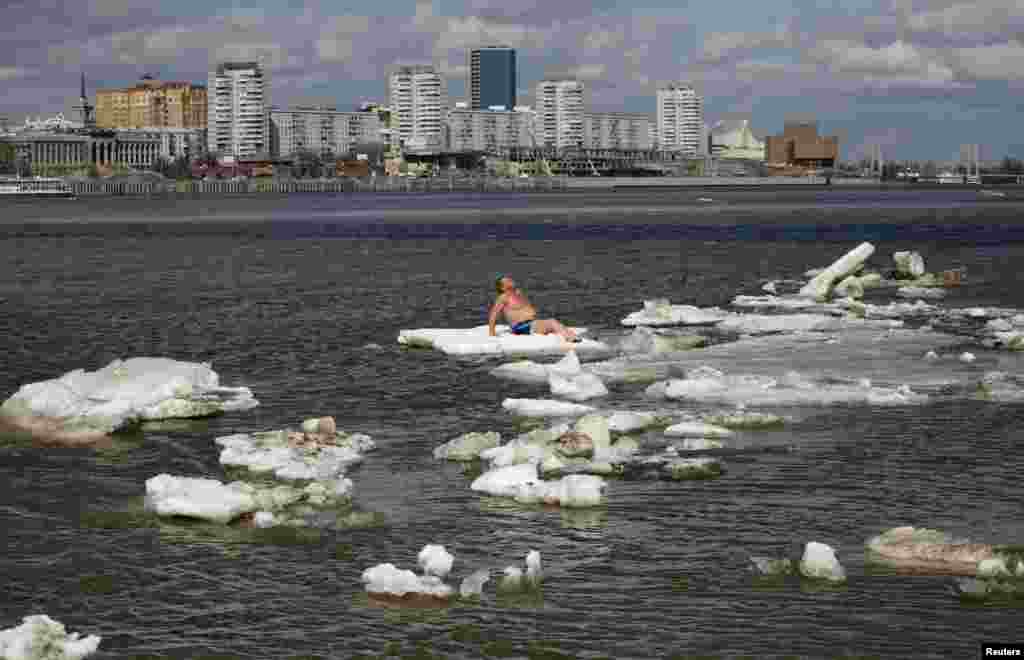 Vladimir Samsonov, a resident from the Siberian town of Zheleznogorsk and a member of the Cryophil winter swimmers club, sunbathes on an ice floe on the Yenisei River in Krasnoyarsk, Russia.