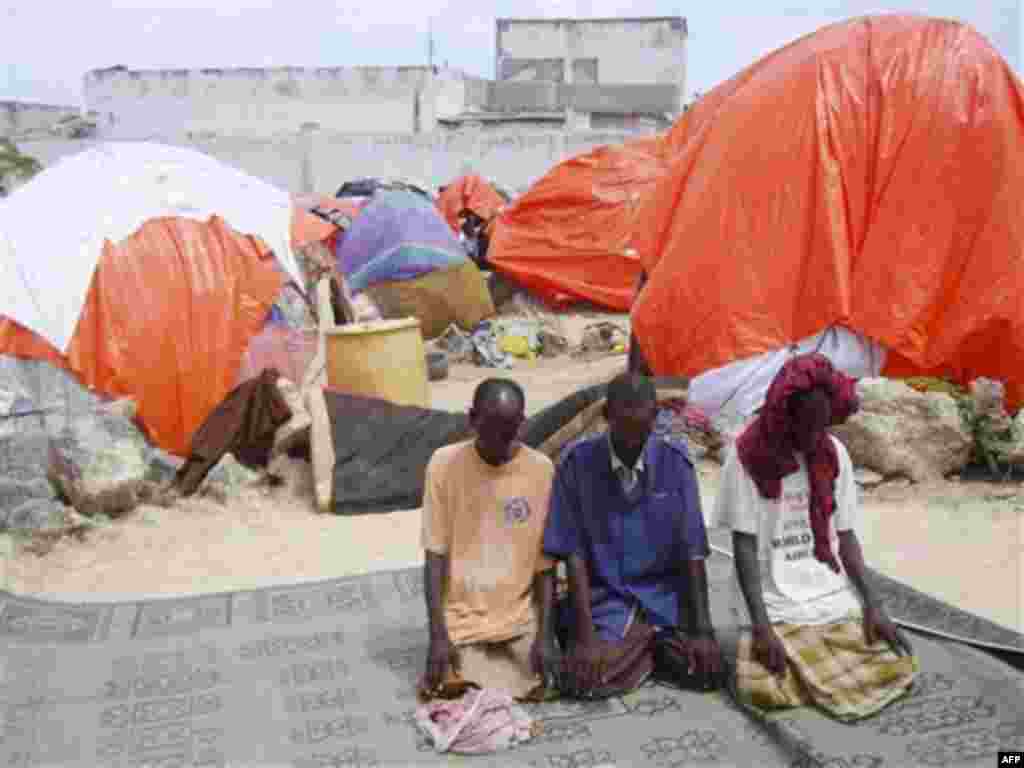 Somalis from southern Somali pray outside their makeshift shelter during Ramadan, at a refugee camp in Mogadishu, Somalia, Saturday, Aug, 6, 2011. The United Nations predict that famine will probably spread to all of southern Somalia within a month and f