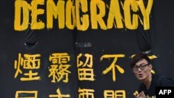 一名香港民主派抗議者站在橫幅前。 （2014年9月30日資料照）