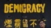 FILE - A pro-democracy protester stands next to a banner in Hong Kong, Sept. 30, 2014. 