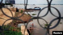 A fisherman casts his net in the Mekong River in Phnom Penh, Cambodia, Nov. 7, 2012. 