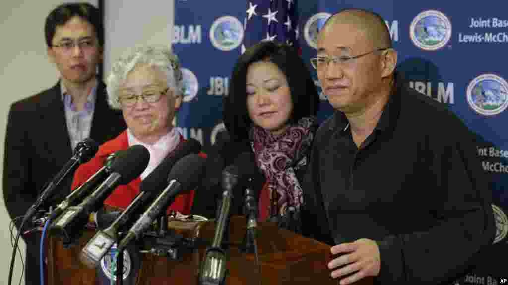 Family members watch as Kenneth Bae, right, freed during a top-secret mission, talks to reporters after he arrived at Joint Base Lewis-McChord, Washington, Nov. 8, 2014.