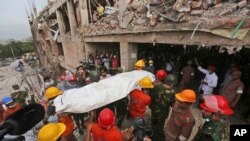 Bangladeshi rescue workers carry the body of a dead garment worker after it was retrieved from a building that collapsed on Wednesday in Savar, near Dhaka, Bangladesh, April 28, 2013.