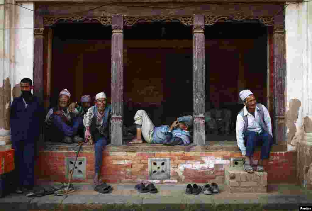 Men pass their time sitting along a street in Bhaktapur, Nepal.