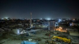 Construction work on a highway flyover in a portion cleared of graves in the City of Dead in Cairo, Egypt, Sunday, July 26, 2020. The overpass cuts through the Southern Cemetery.