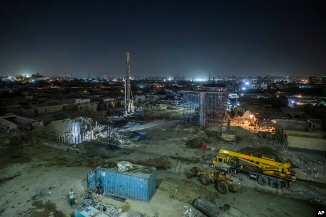 Construction work on a highway flyover in a portion cleared of graves in the City of Dead in Cairo, Egypt, Sunday, July 26, 2020. The overpass cuts through the Southern Cemetery.