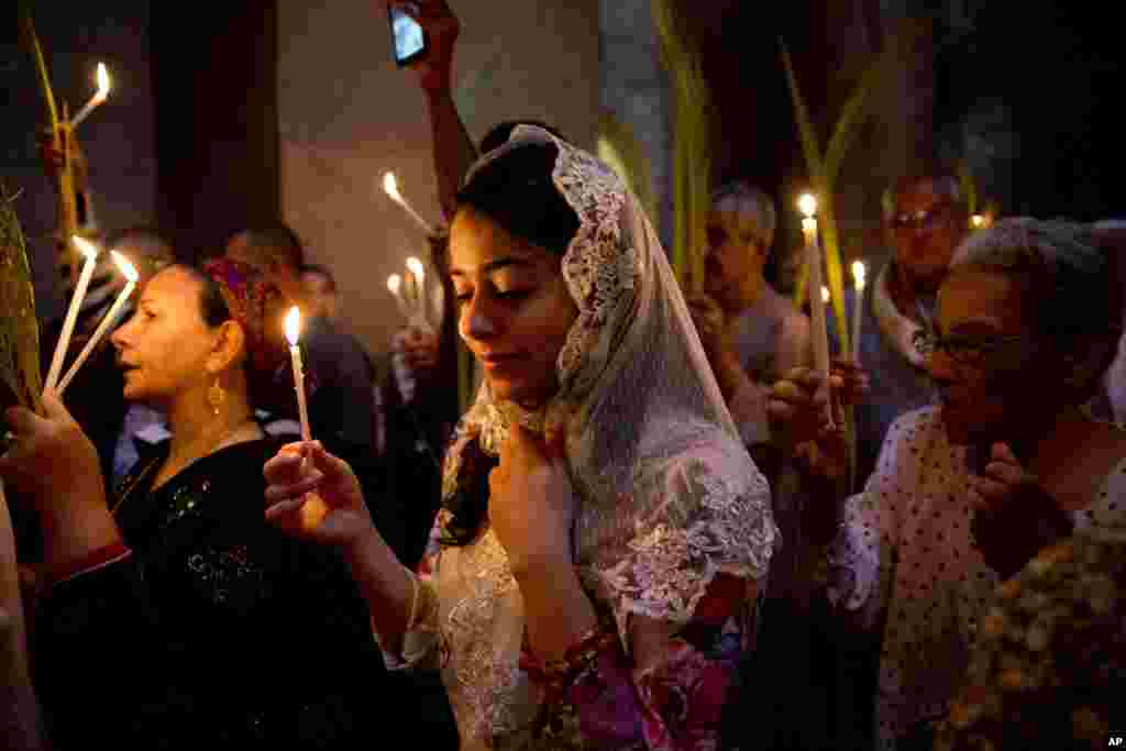 이스라엘 예루살렘 성분묘기념성당의 종려주일 미사에서 신자들이 촛불을 들고 있다. 성분묘기념성당은 예수의 무덤 자리로 여겨지는 곳 위에 세워졌다.