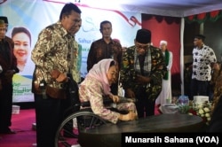 Pada akhir acara Sahur Bersama Lintas Iman Ny. Shita Nuriyah Abdurrahman Wahid membubuhkan tanda tangan prasasti gereja St.Maria Assumpta Gamping, Sabtu (26/5/2018) (foto: VOA/Munarsih Sahana)