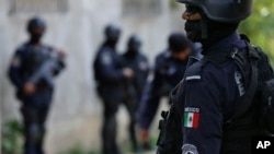 FILE - Police officers patrol poor neighborhoods of Acapulco, Mexico, June 21, 2018. 