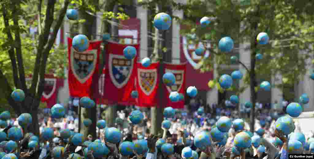 Harvard graduates throw miniature globes in the air during Harvard University commencement ceremonies in Cambridge, Massachusetts, USA.