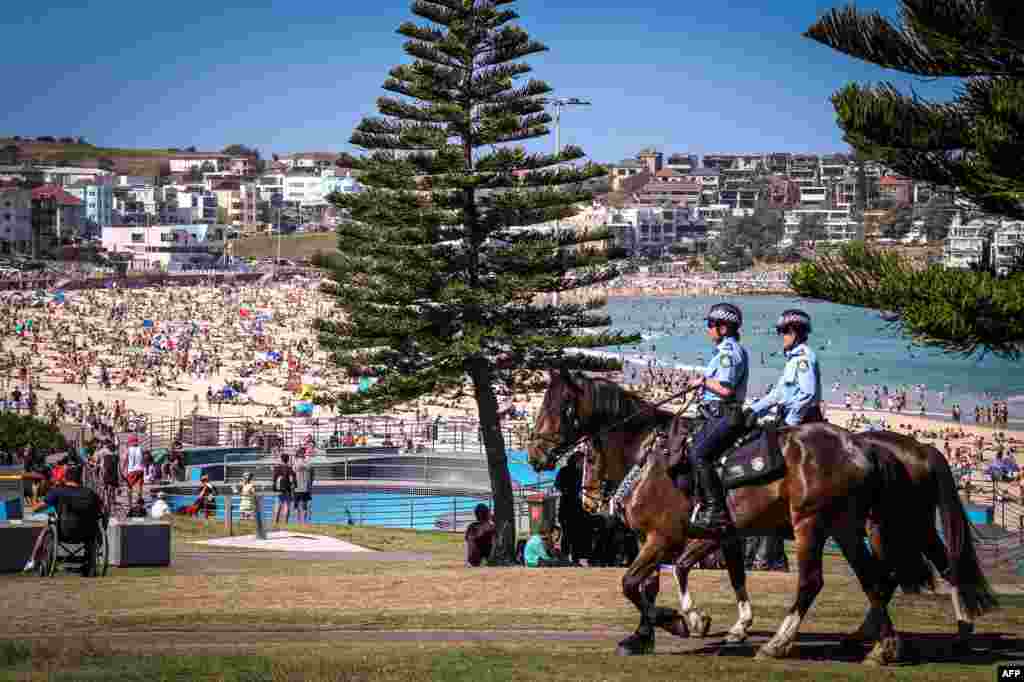 Police on horses patrol as people visit Bondi beach in Sydney, Australia.