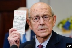 Supreme Court Associate Justice Stephen Breyer holds up a copy of the United States Constitution as he announces his retirement in the Roosevelt Room of the White House in Washington, Jan. 27, 2022.
