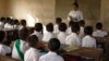 ရန်ကုန်မြို့ လှိုင်သာယာမြို့နယ်ရှိ အခြေခံပညာ မူလတန်းကျောင်းတကျောင်းက ကျောင်းသားများနဲ့ ဆရာမ တဦး။ (ဇွန် ၀၂၊ ၂၀၀၈)