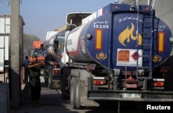 A member of Palestinian security forces gestures as a fuel tanker arrives at Kerem Shalom crossing in Rafah in the southern Gaza Strip, Aug. 15, 2018.