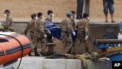 Militer Italia mengangkut jenazah para migran Afrika yang tenggelam di dekat Pulau Lampedusa (6/10).