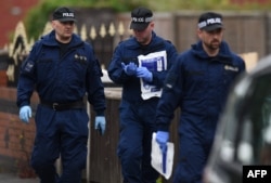 Police officers arrive at a residential property on Elsmore Road in Fallowfield, Manchester, on May 24, 2017, as investigations continue into the May 22 terror attack at the Manchester Arena.