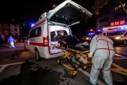 Medical staff transfer a patient infected by the COVID-19 coronavirus on an ambulance to Leishenshan Hospital, the newly-built hospital for the COVID-19 coronavirus patients, in Wuhan in China's central Hubei province on March 3, 2020.