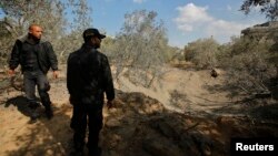 Palestinian policemen loyal to Hamas inspect the scene of an Israeli air strike in the northern Gaza Strip Oct. 28, 2013. 