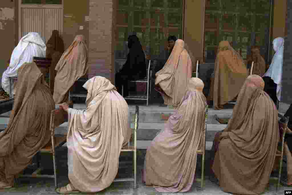 Women wearing burqas queue to collect financial assistance through the Ehsaas Emergency Cash program for families in need, ahead of the Holy month of Ramadan in Peshawar, Pakistan.