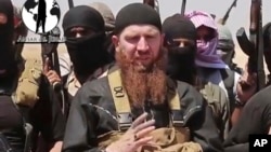 FILE - Abu Omar al-Shishani, seen in an image from video posted on social media June 28, 2014, stands among a group of fighters as Islamic State declares elimination of border between Iraq and Syria.