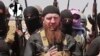 FILE - Omar al-Shishani standing next to Islamic State of Iraq and the Levant (ISIL) spokesman among a group of fighters as they declare elimination of border between Iraq and Syria.