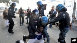 La police italienne aux prise avec un migrant qui tente de traverser la frontière par la force,à Ventimiglia, à la frontière de la France et l'Italie, June 16, 2015.