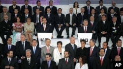 Surrounded by fellow journalists, news media owners, analysts, among others, Carlos Loret de Mola, center left, and Sergio Sarmiento, center right, speak at Mexico Initiative 2011 in Mexico City, March 24, 2011