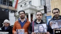 FILE - Campaigners hold posters of jailed British-Iranian woman Nazanin Zaghari-Ratcliffe at the Iranian Embassy in London, Feb. 21, 2018.