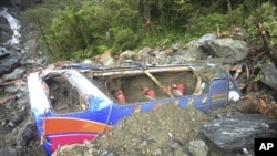 A tour bus is seen engulfed by a land slide caused by heavy rains from passing Typhoon Megi on the coast highway in Ilan county, north eastern Taiwan, 23 Oct 2010