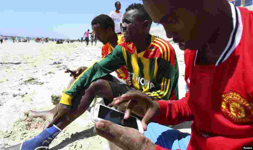 Seorang laki-laki Somalia menelusuri internet di telepon genggamnya di pantai sepanjang pesisir Samudera Hindia di Mogadishu. Kelompok pemberontak al Shabab telah melarang penggunaan Internet di negara Tanduk Afrika itu, dan memberikan jangka waktu 15 hari kepada para operator telekomunikasi untuk mematuhi perintah itu.