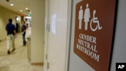 FILE- A sign marks the entrance to a gender-neutral restroom at the University of Vermont in Burlington, Vermont.