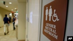 FILE- A sign marks the entrance to a gender-neutral restroom at the University of Vermont in Burlington, Vermont.