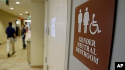FILE - A sign marks the entrance to a gender-neutral restroom at the University of Vermont in Burlington, Vermont. The Obama administration has issued guidance for transgender students in the United States to be allowed to use the bathrooms that match their gender identity.