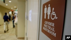 FILE- A sign marks the entrance to a gender-neutral restroom at the University of Vermont in Burlington, Vermont.