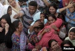 Family members mourn the death of a relative, who was killed in a blast outside a public park on Sunday, during funeral in Lahore, Pakistan, March 28, 2016.