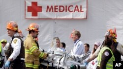 Nhân viên y tế cứu cấp người bị thương sau 2 vụ nổ gần mức đến của cuộc đua Marathon ở Boston, 15/4/13