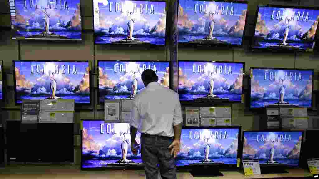 Un potentiel acheteur contemple des postes téléviseurs dans un magasin Best Buy à Franklin, Tennessee, le 23 Novembre, de 2012.